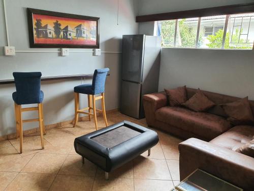 a living room with a couch and two chairs at Mabel Guesthouse in Cape Town