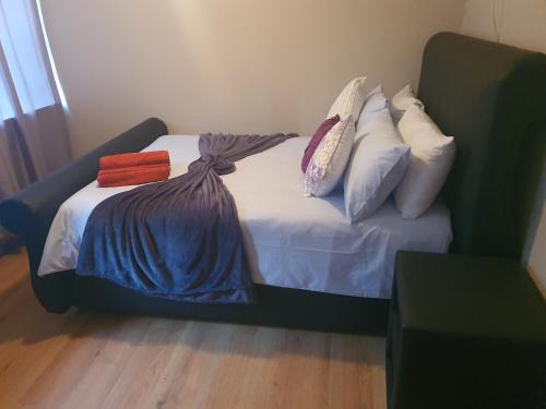 a bed with pillows on it in a room at Mabel Guesthouse in Cape Town