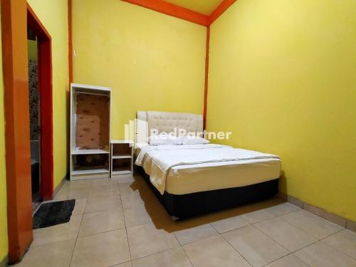 Un pat sau paturi într-o cameră la Hotel Hing Amimah Mitra RedDoorz
