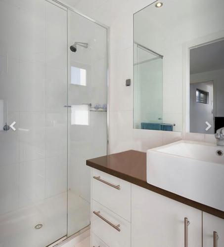 a white bathroom with a sink and a shower at Bundalong river retreat in Bundalong
