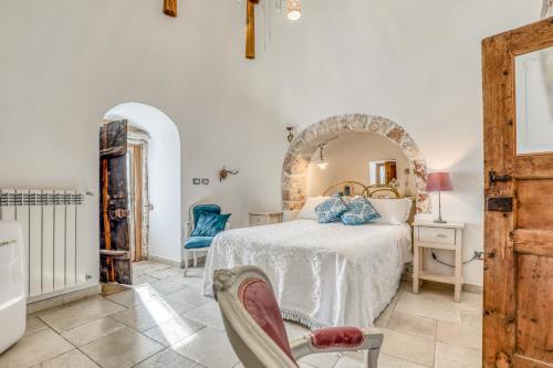 a bedroom with a bed and a chair at Trulli Terra Magica in Putignano