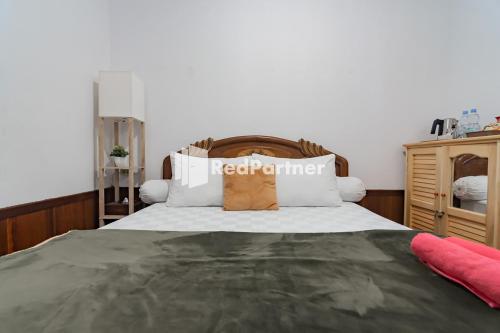 A bed or beds in a room at Langkar Guest House Syariah Mitra RedDoorz
