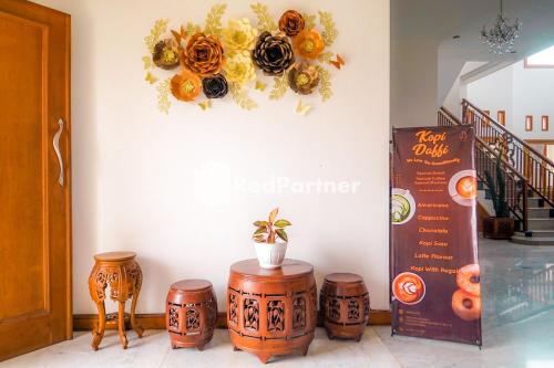 a wall with a flower wreath on a wall at RedDoorz at Daffi Araya in Malang
