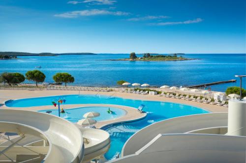 a resort swimming pool with a view of the ocean at Maistra Select Villas Rubin Resort in Rovinj