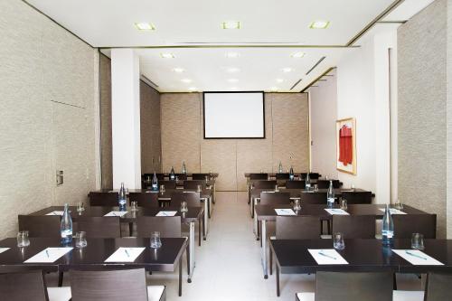 a conference room with tables and a projection screen at Grupotel Gran Via 678 in Barcelona