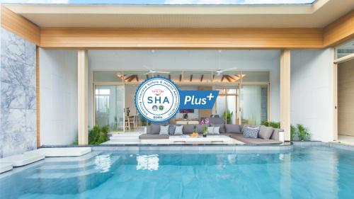 a hotel swimming pool with a sign that reads shea plus at Himmapana Villas - SHA Extra Plus in Kamala Beach