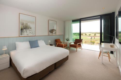 1 dormitorio con 1 cama, TV y escritorio en The Sands Torquay en Torquay