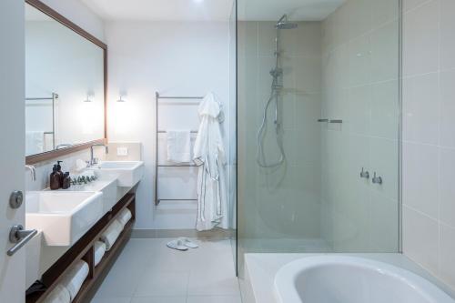 a bathroom with two sinks and a glass shower at The Sands Torquay in Torquay