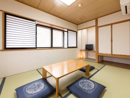 una stanza con un tavolo e due cuscini blu di Tateyama Kurobe Alpine Route Senjuso 立山黒部アルペンルート千寿荘 a Tateyama