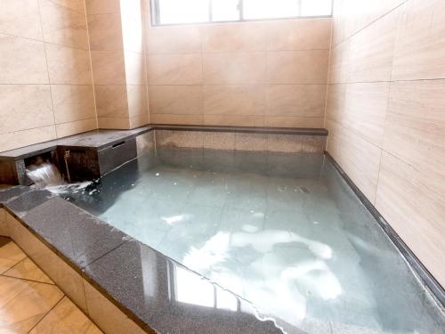 a jacuzzi tub in a room with water at Tateyama Kurobe Alpine Route Senjuso 立山黒部アルペンルート千寿荘 in Tateyama