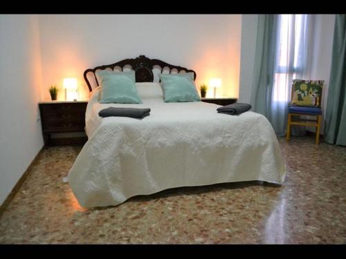 a bedroom with a large white bed with blue pillows at 1 bedroom Apartment with Gallery Balcony Free Netflix, air conditioning in Alicante