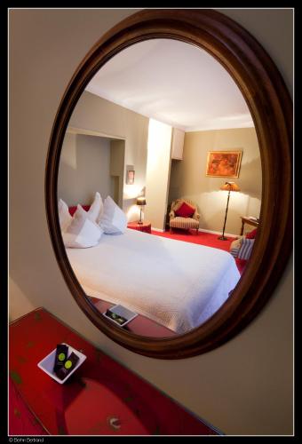 a hotel room with a bed in a mirror at Hotel de la Gaichel in Eischen