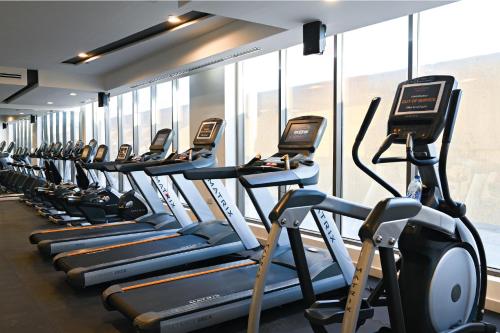 a gym with a row of treadmills at TIME Asma Hotel in Dubai