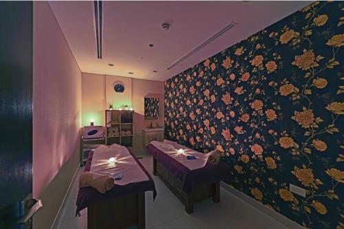 a restaurant with two tables and a wall with flowers at TIME Asma Hotel in Dubai