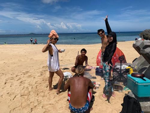a group of people standing on the beach at Happy Island Miyako in Miyako Island