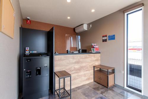 a kitchen with a refrigerator and a counter at HOTEL R9 The Yard Nakatsu in Nakatsu