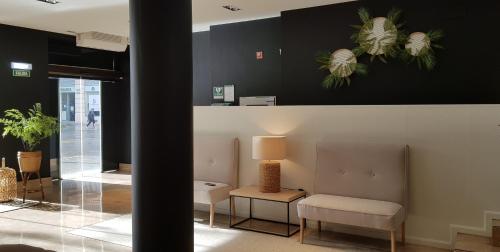 a waiting room with a chair and a table at Hotel Oriente in Zaragoza