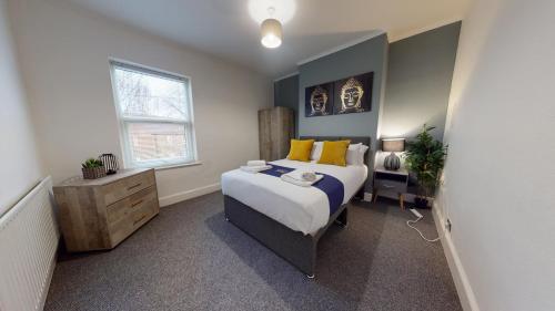 a bedroom with a large bed with yellow pillows at Station House By Horizons Stays in Darlington