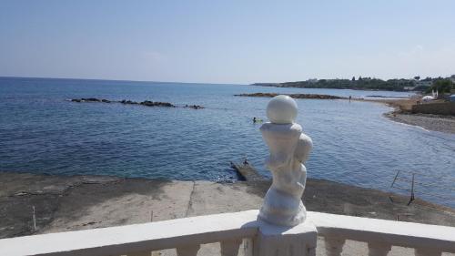 a white statue sitting on a railing near the water at Topset Hotel in Kérynia