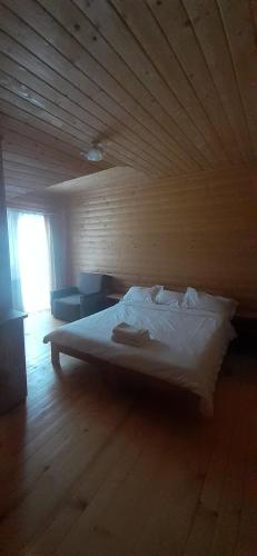 a bed in a room with a wooden wall at Біла хата in Iltsi