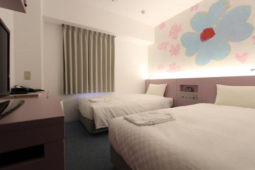 a hotel room with two beds and a desk at KOKO HOTEL Osaka Namba Ebisucho in Osaka
