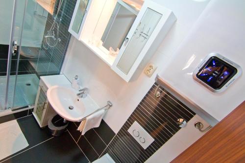 ein Bad mit einem Waschbecken, einer Dusche und einem Spiegel in der Unterkunft Luxury Old Town Suites in Split