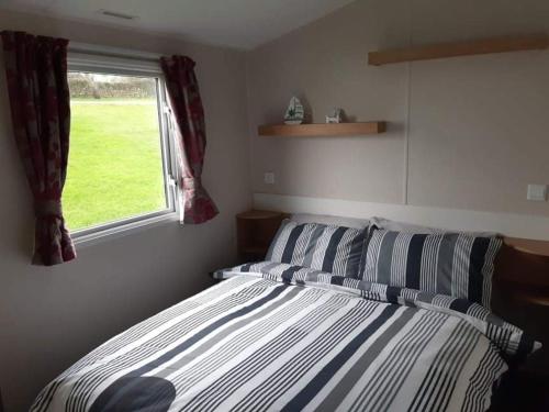 a bedroom with a bed and a window at 58 Newquay View, Newquay Bay Resort in Newquay Bay Resort