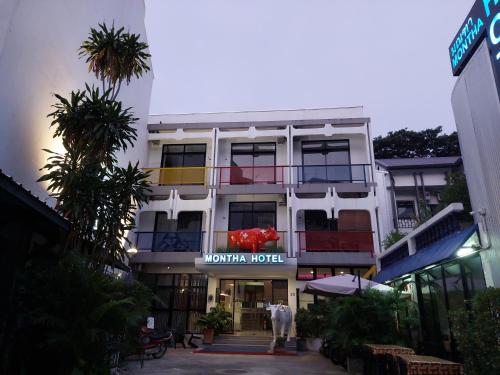 a white building with a sign for a hotel at Hotel Montha in Chiang Mai