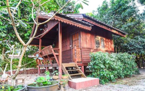 a small wooden house with a staircase in front of it at Pruksa Resort Prachin Buri in Prachin Buri