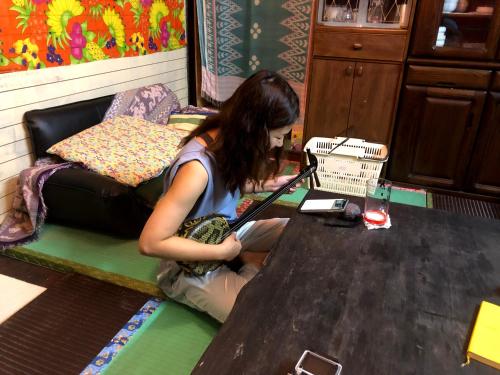 a woman sitting at a table in a room at Happy Island Miyako in Miyako Island