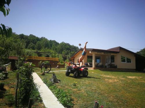 a woman jumping off of a wheeler in a yard at "Porodica MARKOVIC" Borsko jezero in Beljevina