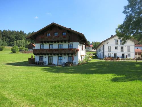 a large building with a grass field in front of it at Ferienhof Landhaus Michael in Böbrach