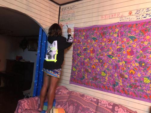 a woman painting a wall with flowers on it at Happy Island Miyako in Miyako Island