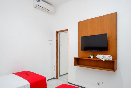 a room with a bed and a flat screen tv at RedDoorz near XT Square 4 in Timuran