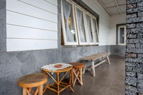 a porch with two tables and two benches and a window at RedDoorz near XT Square 4 in Timuran