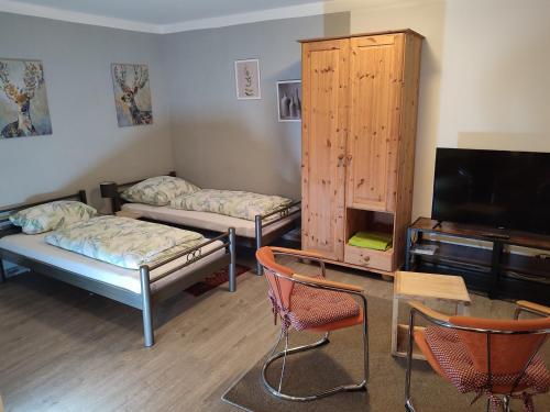 a room with two beds and a flat screen tv at FeWo Am Neckarsteig in Neckarsteinach