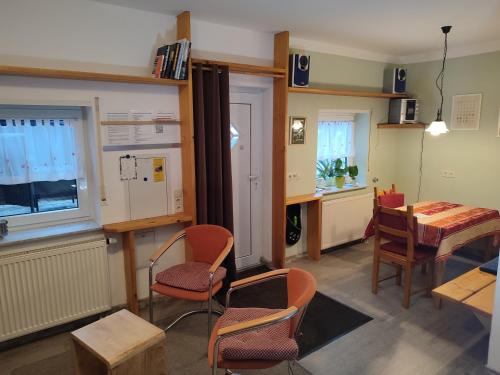 a room with a table and chairs and a table and a kitchen at FeWo Am Neckarsteig in Neckarsteinach