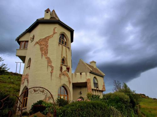 um edifício no topo de uma colina com um céu em Castle in Clarens em Clarens