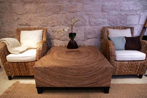 a room with two chairs and a table with a vase on it at B&B Villa Vis in Vis