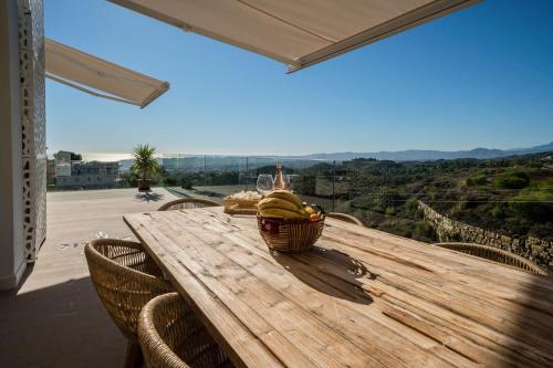 a wooden table with a basket of bananas on it at Casa Carolina - This One in Higuerón with Quality and Peace in Mijas