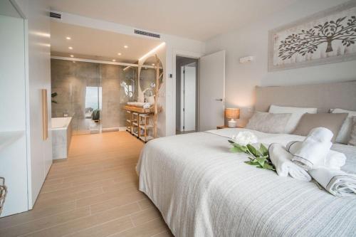 a bedroom with a large white bed and a bathroom at Casa Carolina - This One in Higuerón with Quality and Peace in Mijas