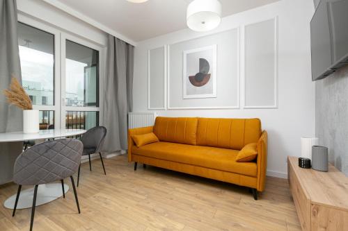 sala de estar con sofá amarillo y mesa en Golden Apartments Ursynów by Renters, en Varsovia
