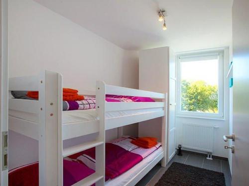 two bunk beds in a room with a window at Leuchtturm Leuchtturm 7 - Dachterrasse mit Meerblick in Großenbrode