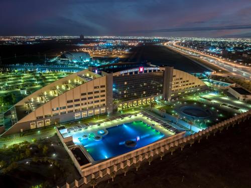 a view of a building with a pool at night at Grand Millennium Tabuk in Tabuk