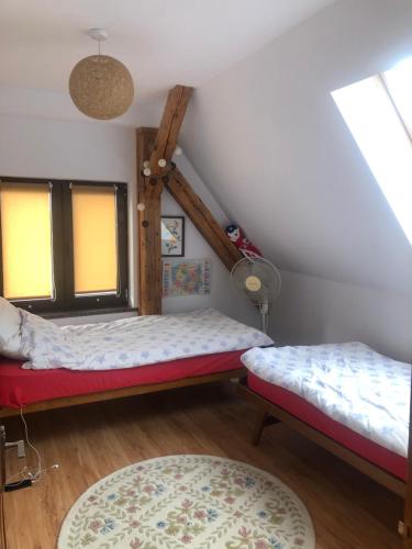 a attic room with two beds and a window at Dom wypoczynkowy Zacisze in Filipów