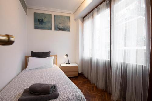 a bedroom with a bed and a large window at UBICACIÓN EXCELENTE para EXPLORAR la REGIÓN in Villabona