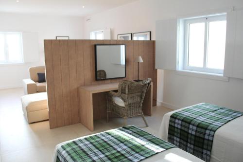 a hotel room with a desk and a mirror at Quintas de Obidos Apartments in Vau
