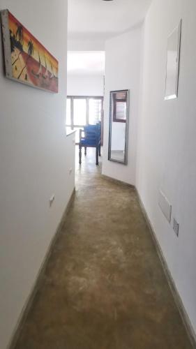 a hallway with white walls and a painting on the wall at Villa Malaika in Jambiani