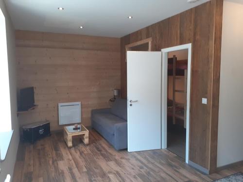 - un salon avec un canapé bleu et une porte dans l'établissement Le Studio Polichinelle, à Gérardmer