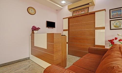 a living room with a couch and a tv at Itsy Hotels Rithika Inn Blossoms in Chennai